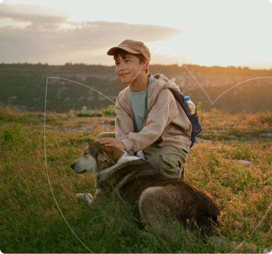 Garoto com cão em campo aberto
